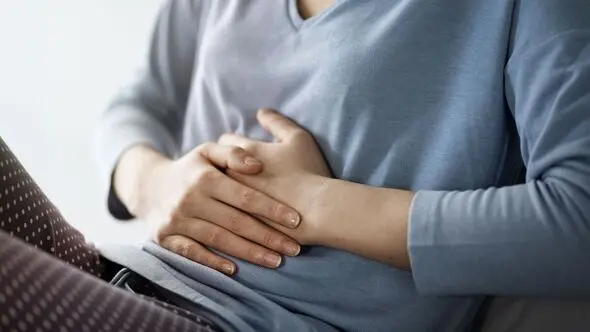 Person holding their abdomen in pain.
